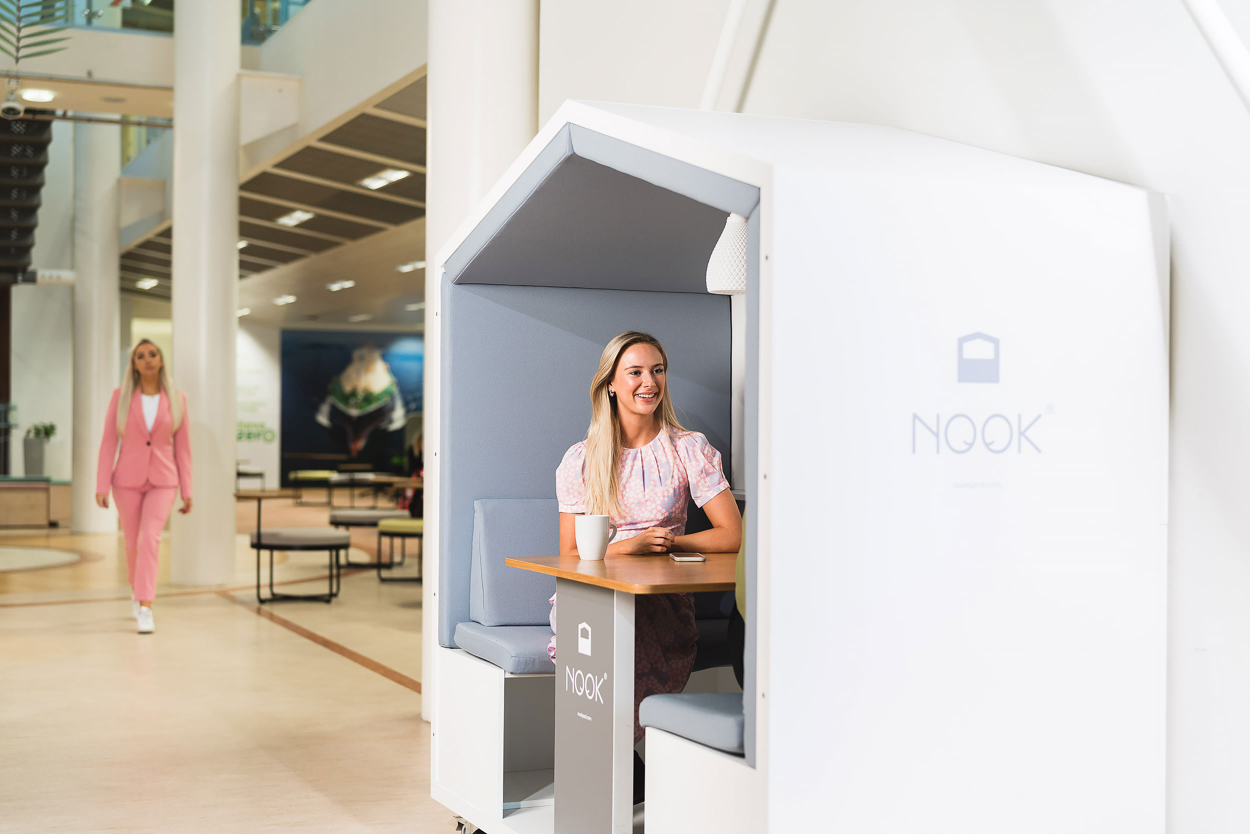 young smiling female office worker in nook booth