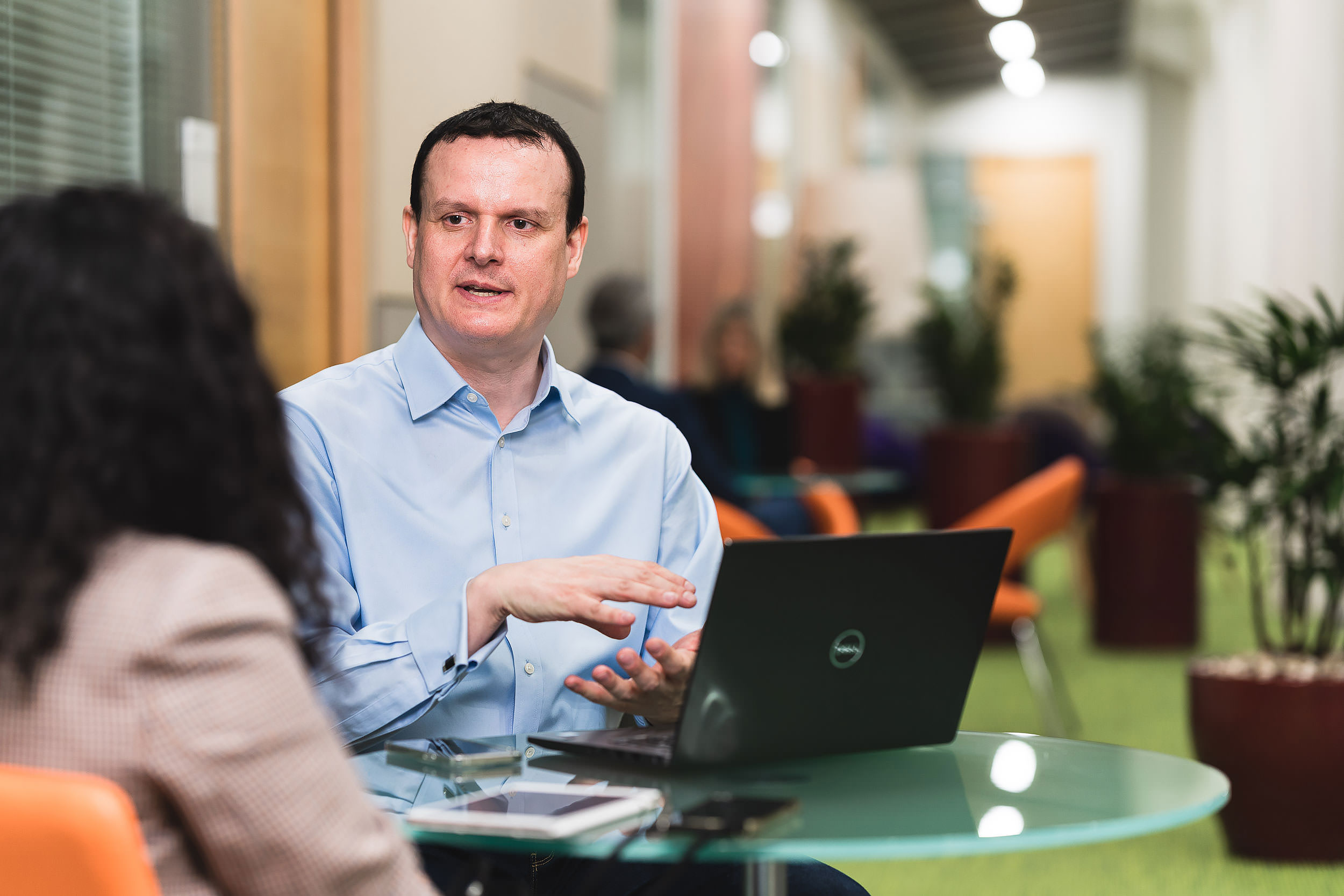 corporate male with laptop talking  to colleague