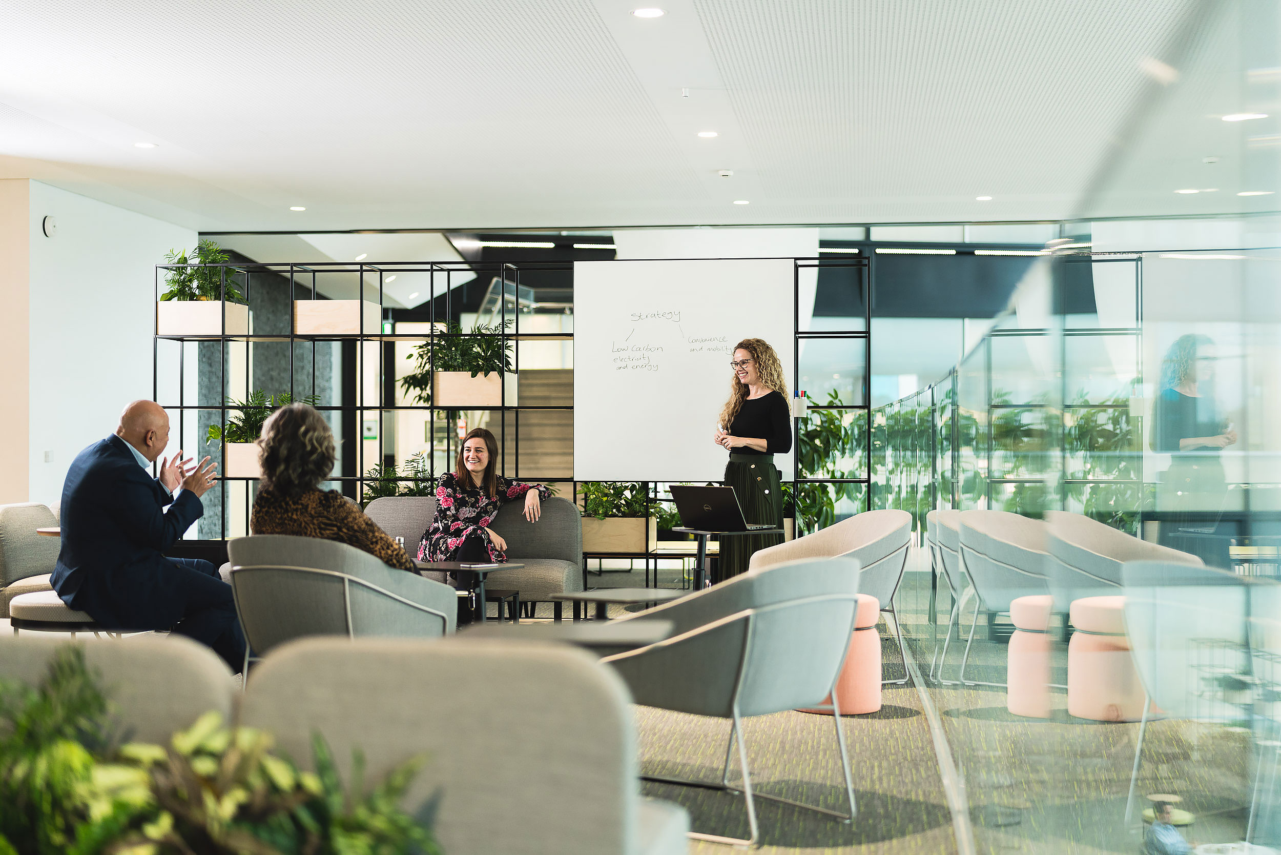 informal corporate meeting in modern open plan workspace with smiling colleagues