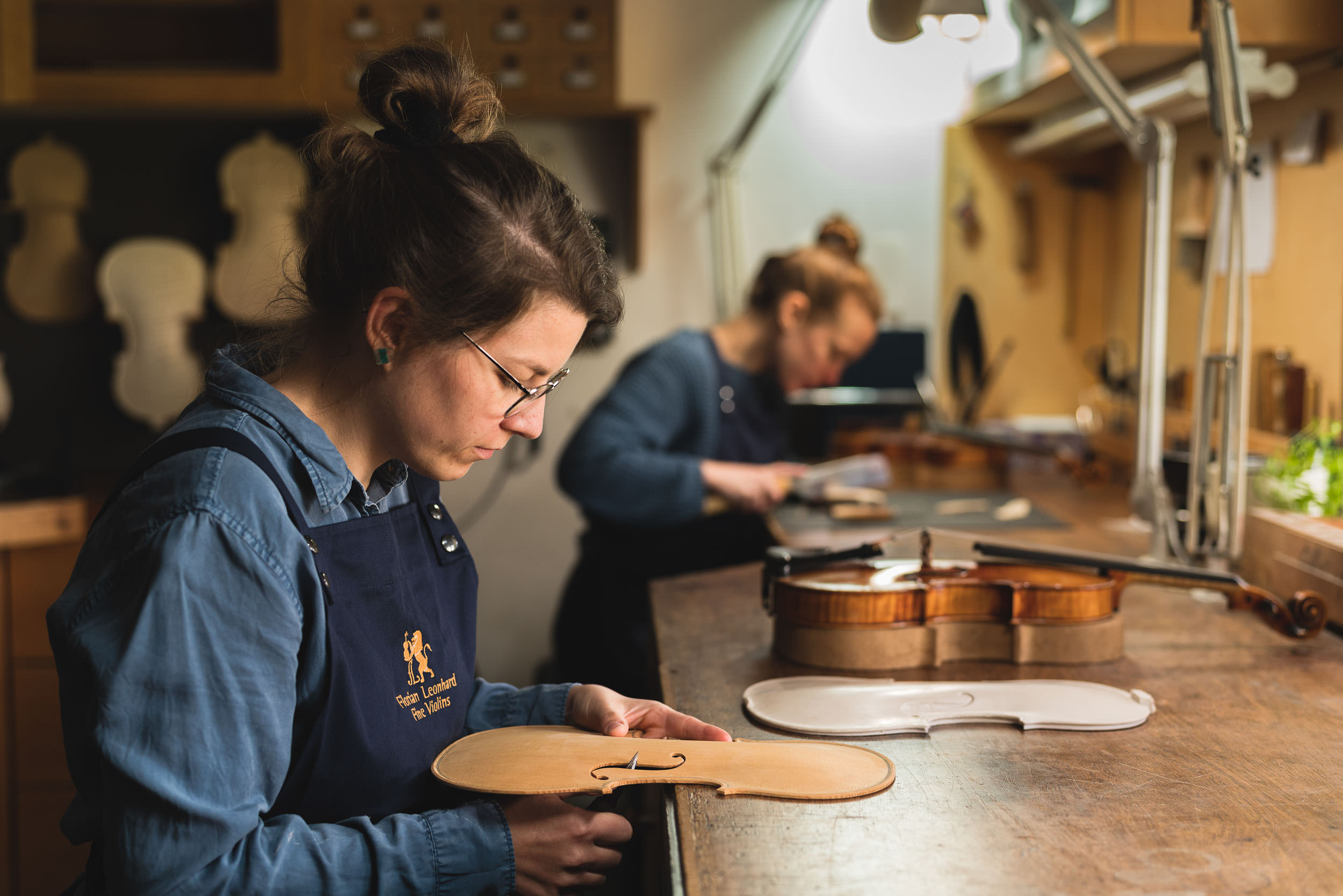 Artisans hand crafting violins in London workshop
