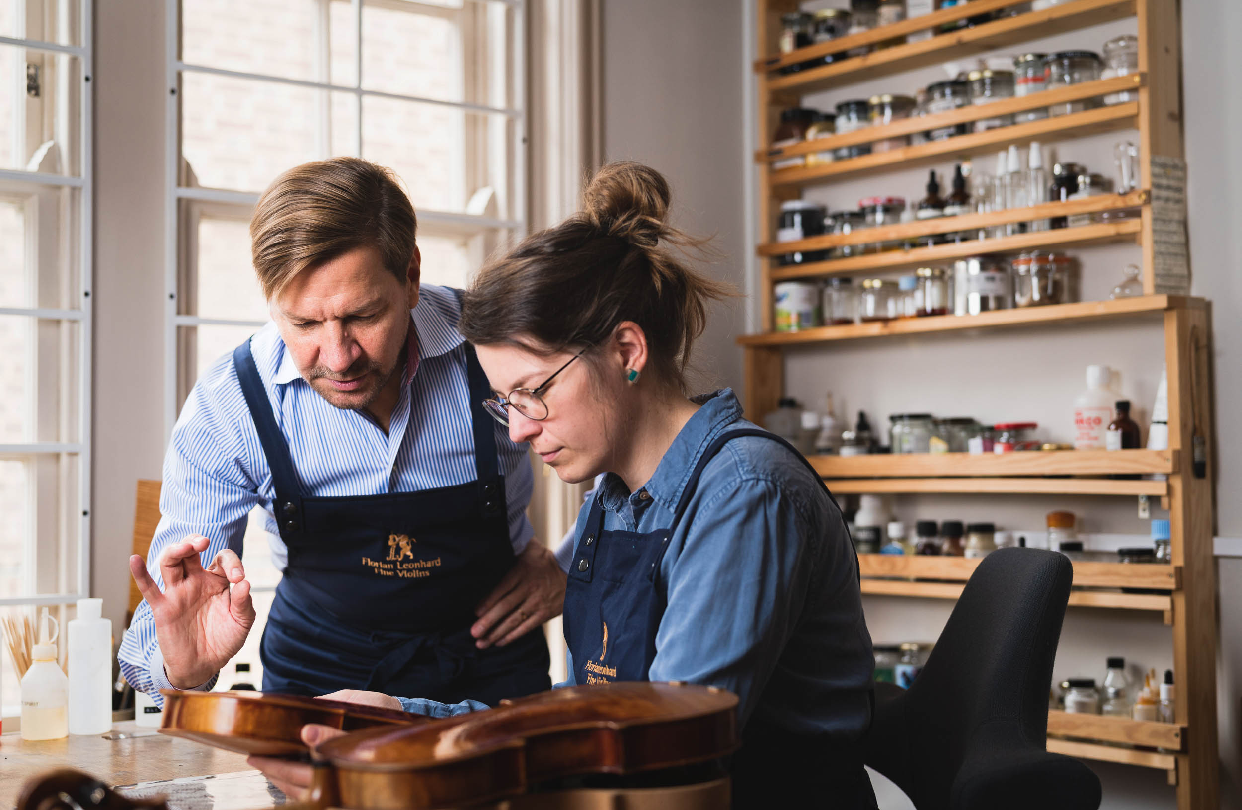 Florian Leonhard and craftsperson in violin making workshop 