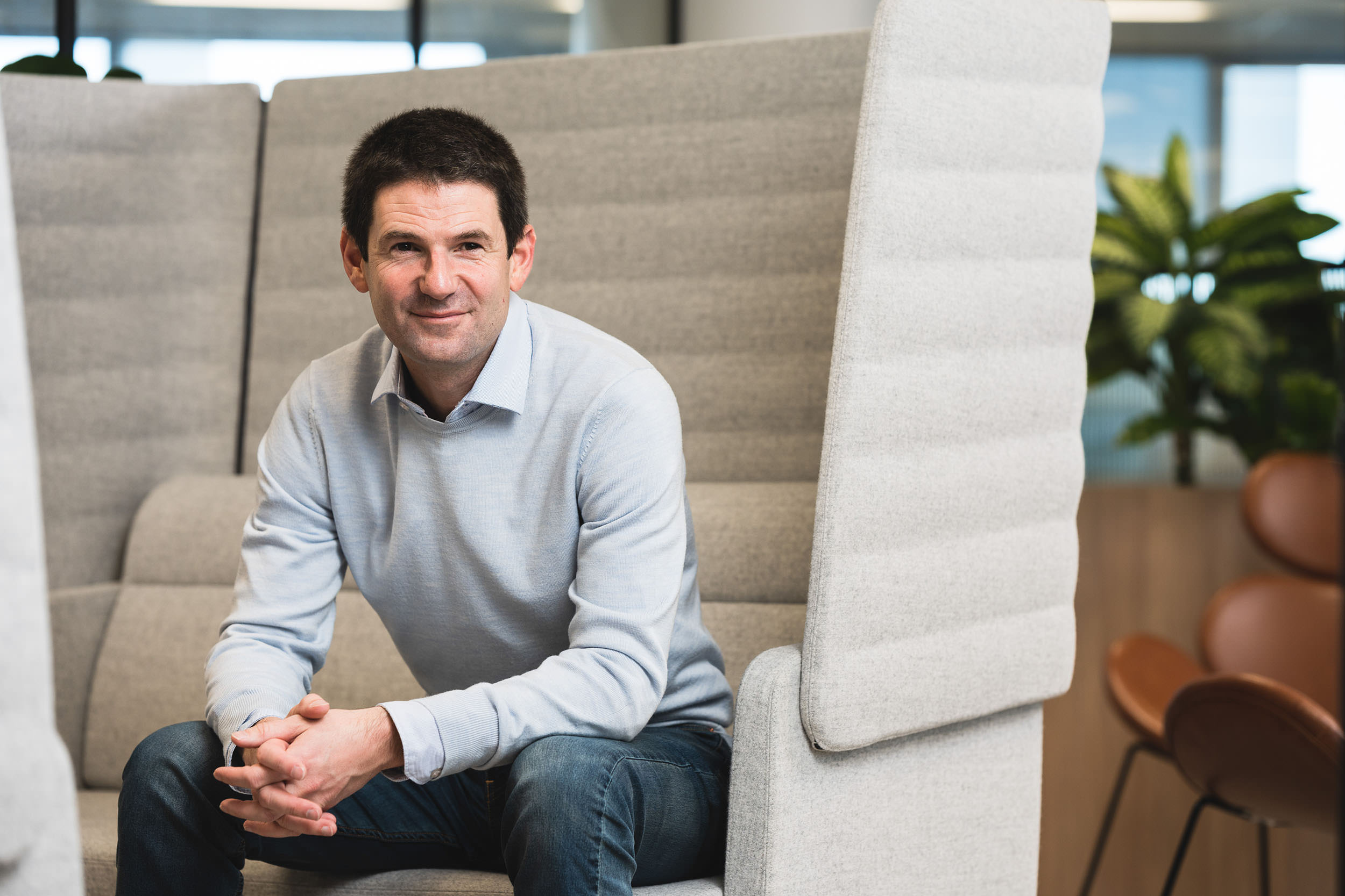 casual corporate portrait of male sitting in contemporary office
